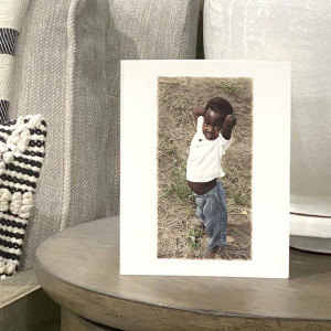 African boy standing outside with his hands resting behind his head