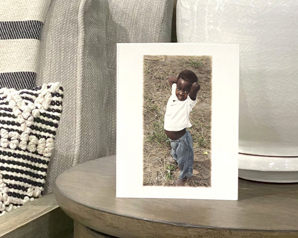 African boy standing outside with his hands resting behind his head