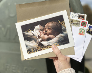 Christmas card with a painting of Baby Jesus sleeping in the manger