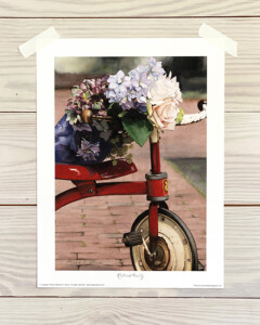 red tricycle with floral bouquet resting on seat and handles