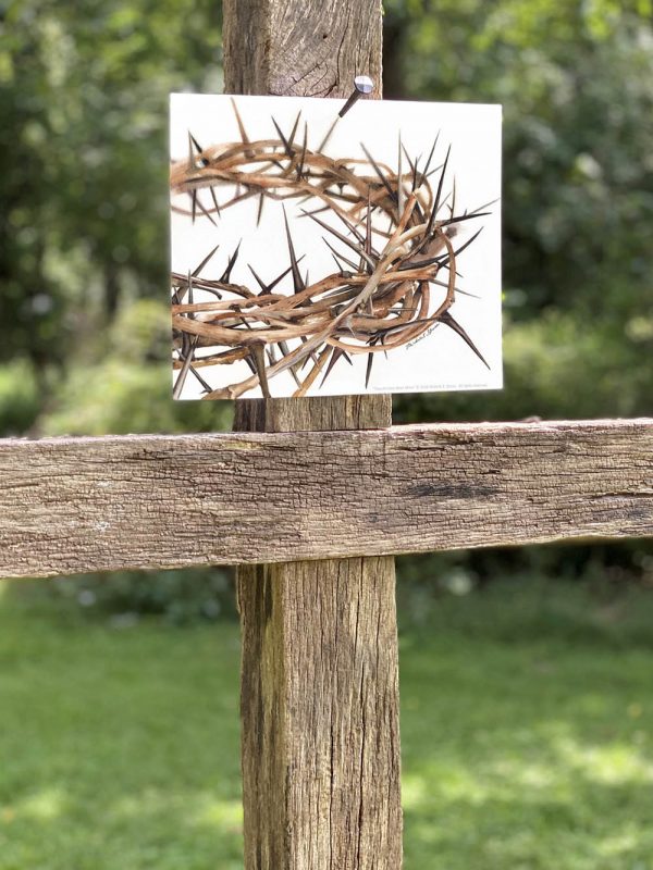 Nailed to a wooden cross is a watercolor art print of a crown of thorns