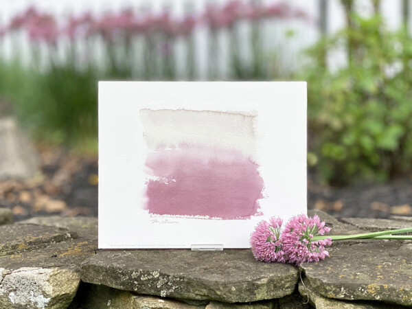 An abstract art print of watercolors blending from light gray to deep plum