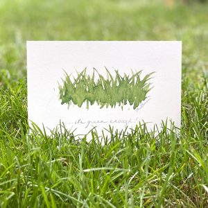 A small art print of painted grass with handwriting that says, "...it's green enough"